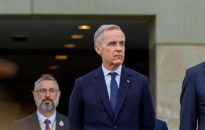 Mark Carney is standing in front of a crowd in Canberra, Australia