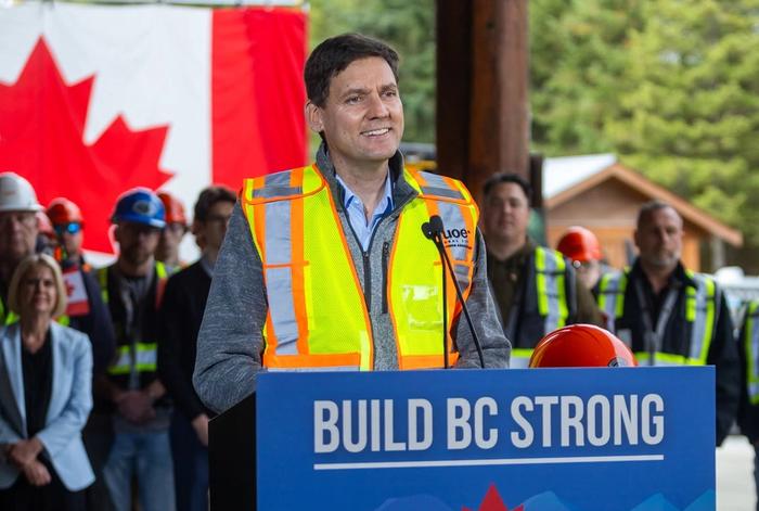 David Eby standing at a podium during one of his campaign stops