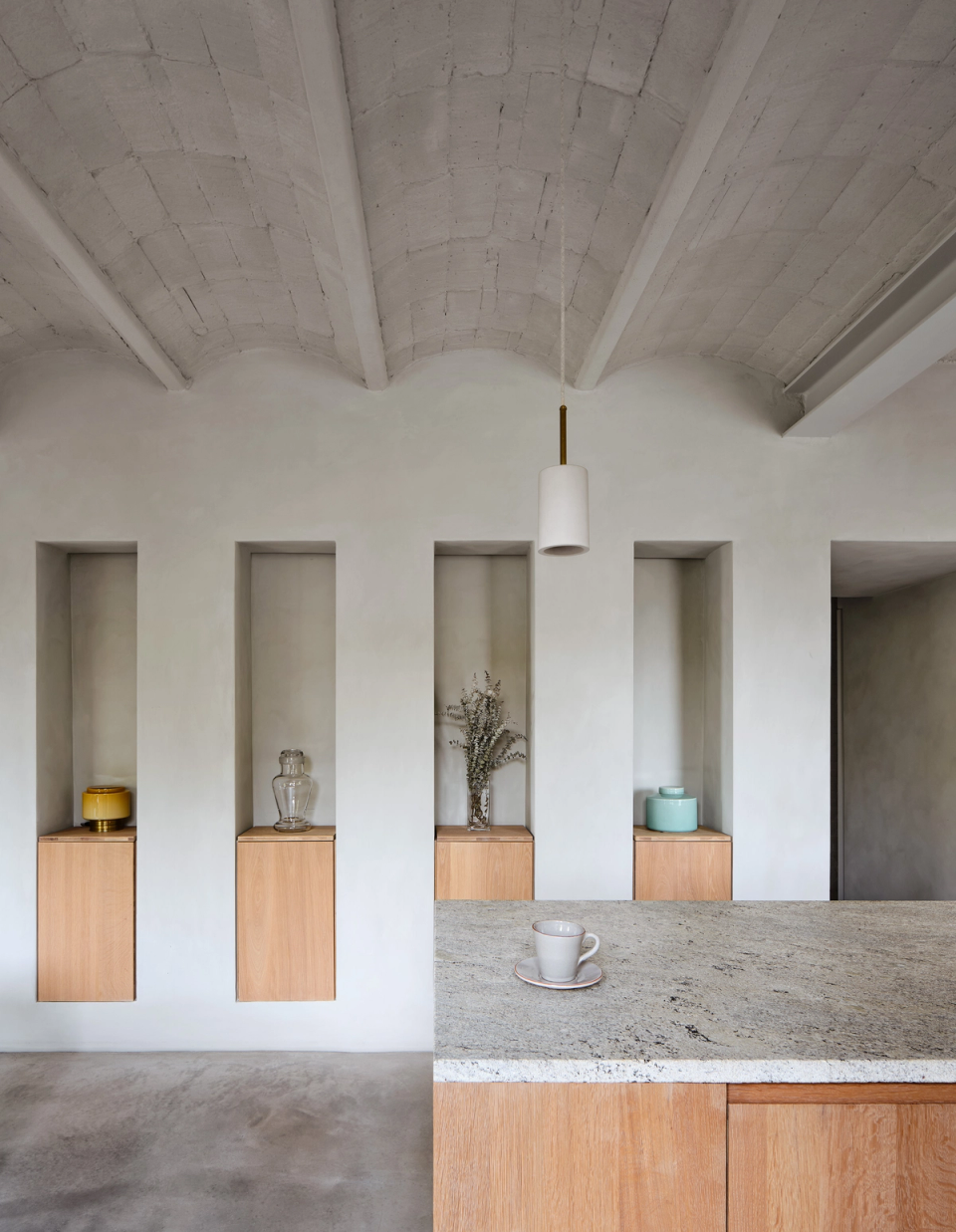 Housing renovation with an open kitchen that restores the original volume and highlights the existing ceilings. The renovation integrates natural materials, soft light and custom furniture to create balanced, warm and functional spaces.