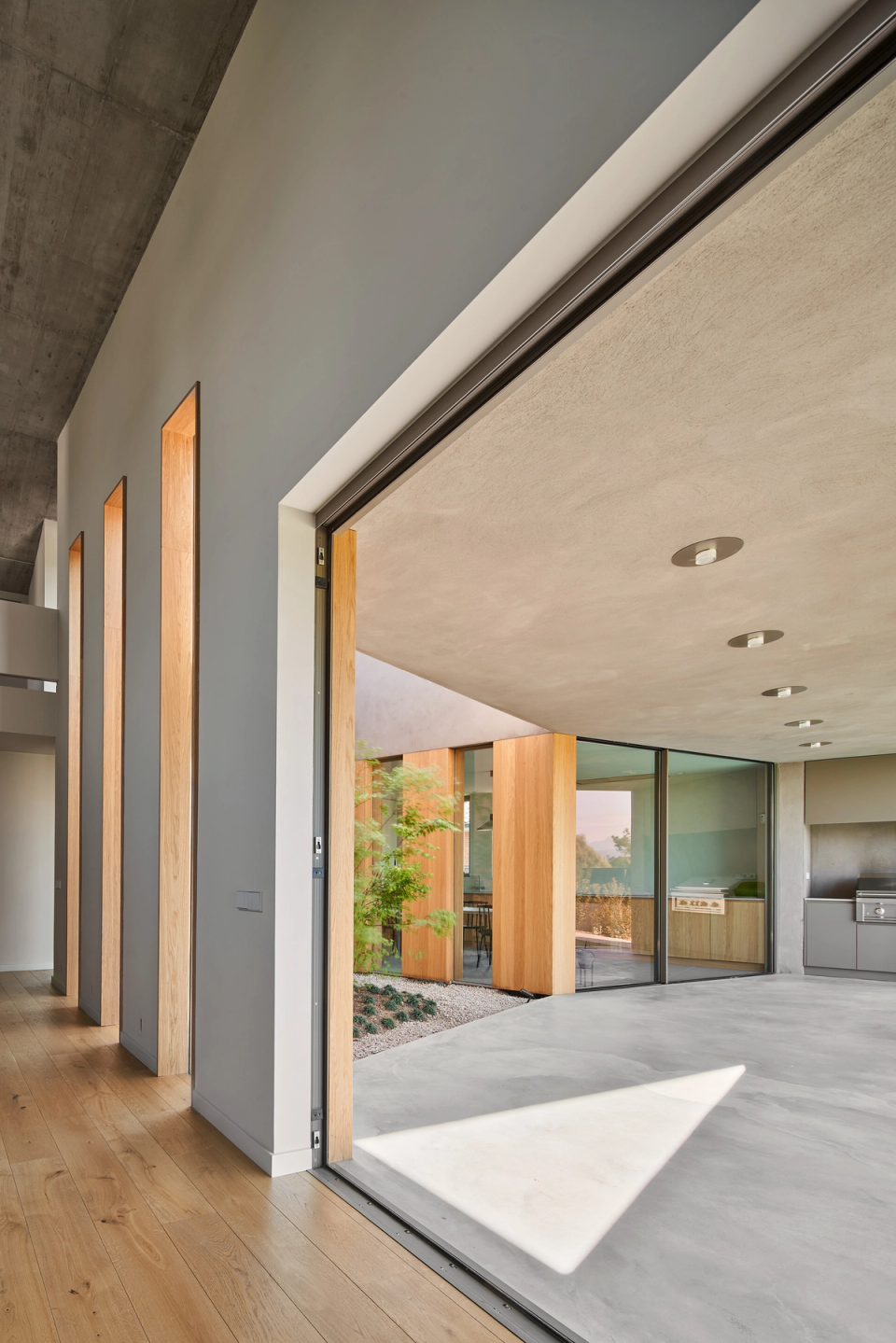The connection between interior and exterior defines this contemporary single-family home, where large openings, natural materials, and open spaces enhance light and the visual continuity of the architecture.