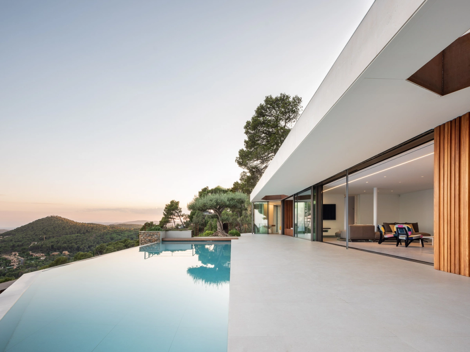 Detached single-family home with contemporary architecture combining clean lines, large openings, and wood cladding to create an elegant and warm aesthetic. The integration between interior and exterior spaces, together with natural light and open views, defines a modern environment designed for comfort and connection with the surroundings.