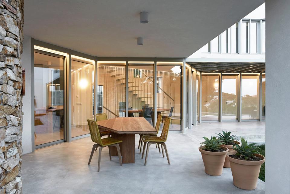 Covered terrace of a detached single-family home with integrated outdoor living space, large glass openings, and contemporary finishes. The design encourages continuity between interior and exterior, creating a comfortable and functional gathering area connected to the home’s architecture.