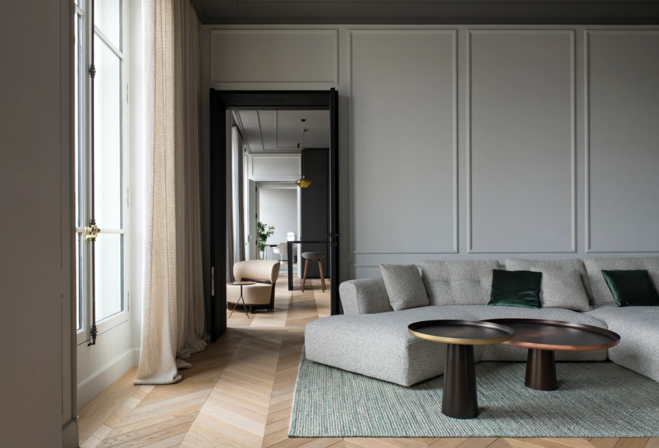 The interior renovation of this space restores the classical essence of the original home while incorporating a contemporary and sophisticated aesthetic. Moldings, herringbone parquet flooring, and a neutral color palette coexist with soft-lined furniture and modern elements, creating an elegant, bright, and timeless atmosphere designed to enhance comfort and the quality of the interior spaces.