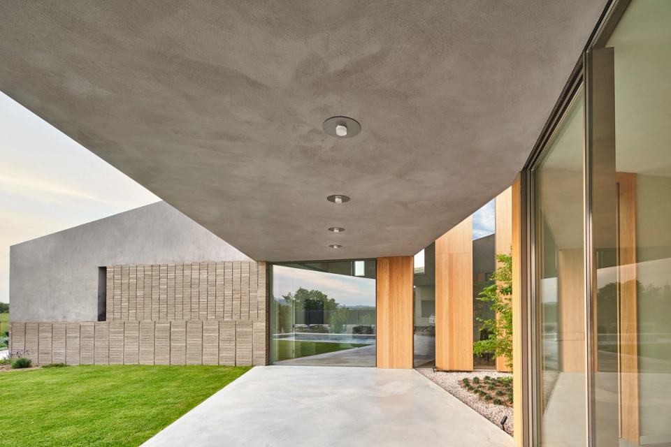 This single-family home combines contemporary volumes, large openings, and natural materials to create elegant and luminous spaces. The porches and glazed surfaces encourage a fluid connection between interior and exterior, bringing spaciousness and comfort to the architecture.