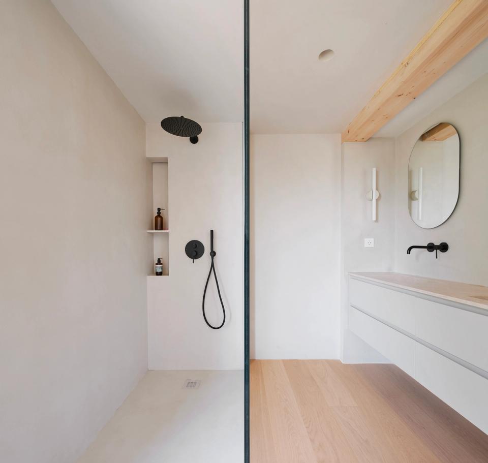 House in Girona with an open and illuminated minimalist bathroom that combines natural materials, clean lines and a functional distribution. This house in Girona is committed to spacious spaces, natural lighting and continuous finishes to create an elegant, serene and comfortable atmosphere.