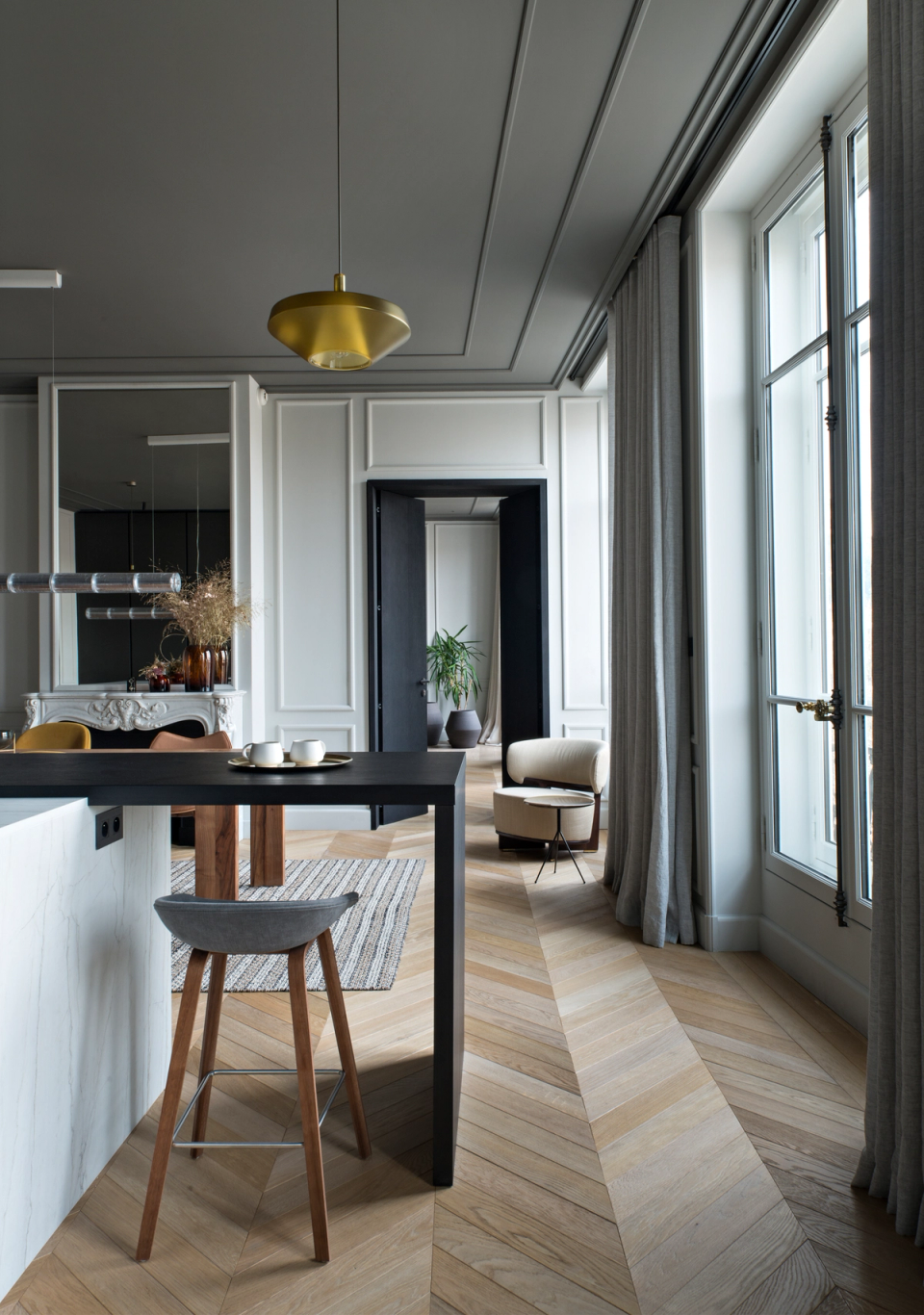 The interior renovation of this home highlights natural light, the original proportions, and classical architectural elements through an elegant and contemporary intervention. The herringbone flooring guides the connection between spaces, while moldings, decorative ceilings, and large openings are combined with minimalist furniture and dark finishes to create a sophisticated contrast. The result is a balanced, warm, and functional interior that updates the home without losing its original essence.