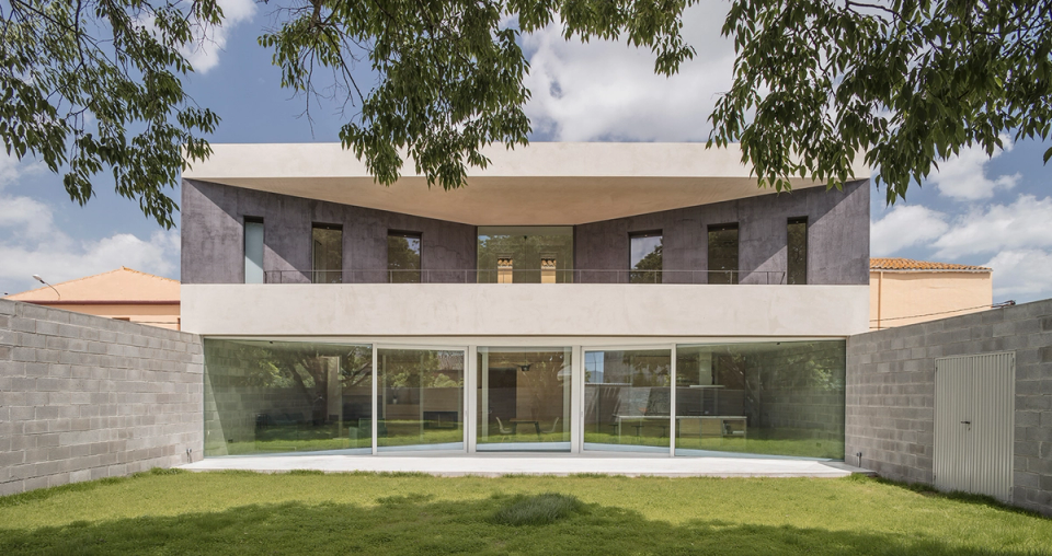 Detached single-family home with modern lines, a symmetrical façade, large windows, and open spaces connected to the garden. The project stands out for its contemporary architecture, the connection between interior and exterior, and the use of restrained materials that provide elegance and residential functionality.