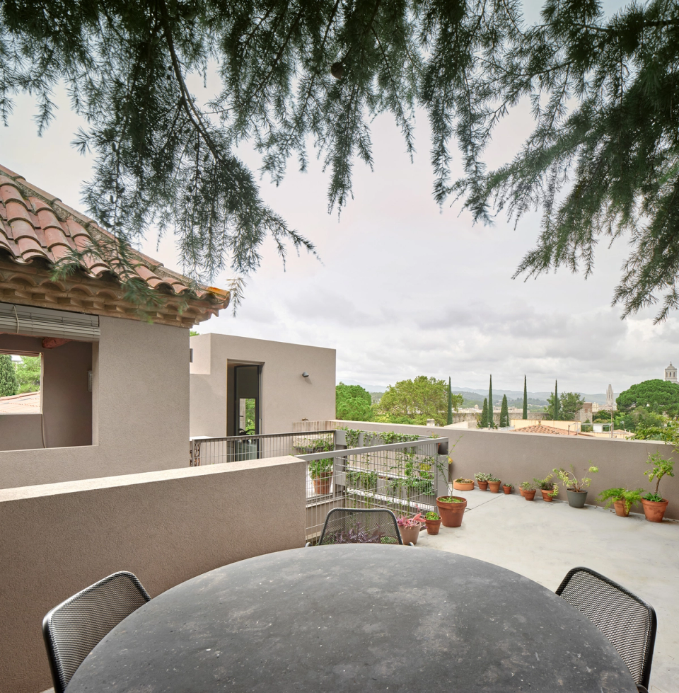 Housing renovation with an open terrace offering wide views and outdoor spaces designed for rest and social life. The renovation connects architecture and landscape through neutral materials, vegetation and a fluid relationship with the surroundings.
