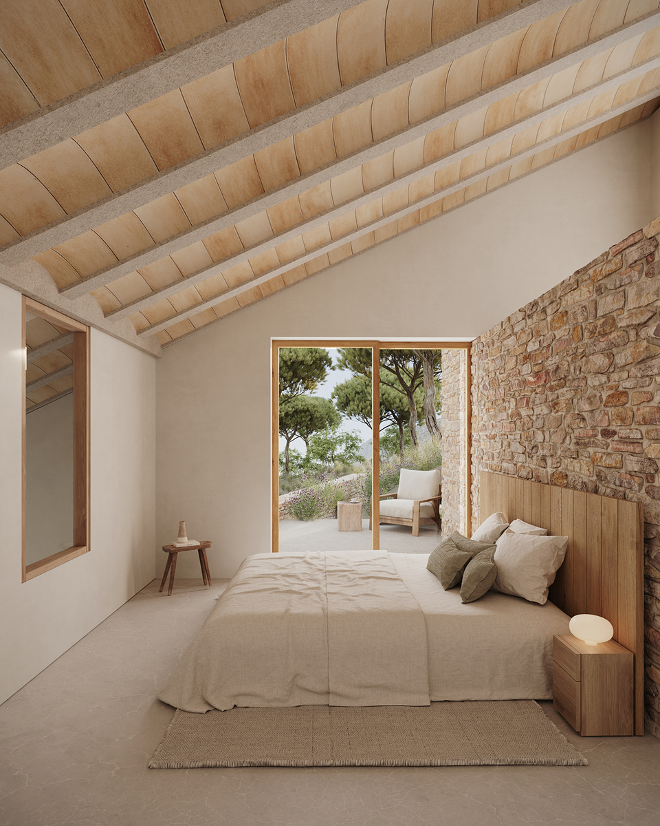 Interior of the house in Tamariu designed with a warm and serene atmosphere, where natural stone, wood, and Mediterranean light define the space. The bedroom visually opens to the exterior through large openings, reinforcing the connection with the landscape and providing a sense of calm, naturalness, and comfort.