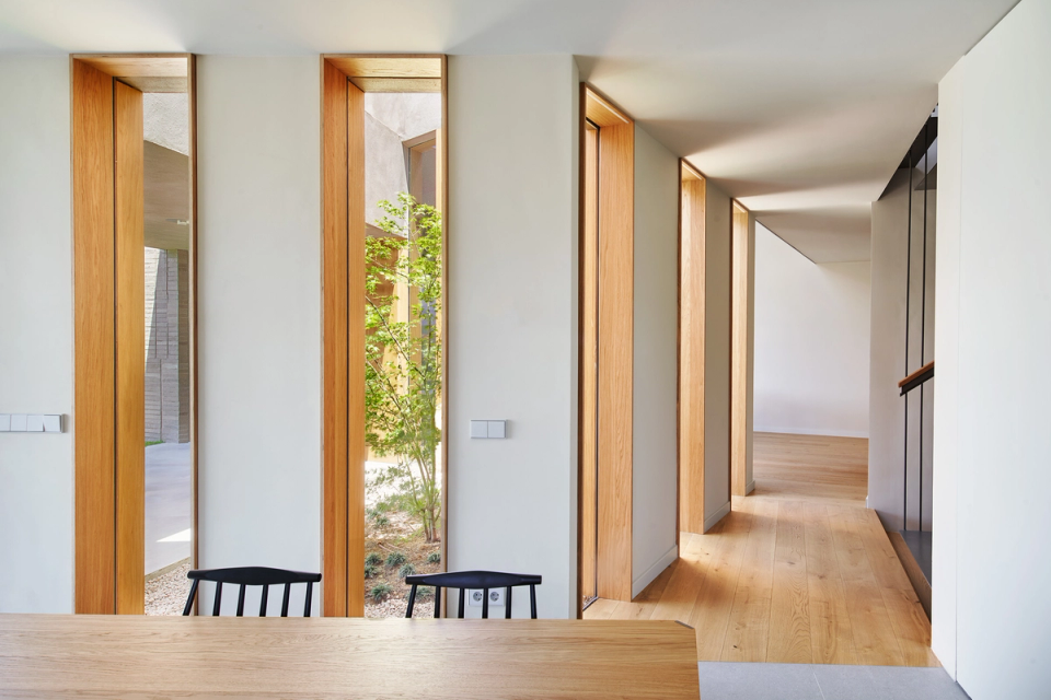 Natural light becomes the protagonist of this single-family home thanks to the vertical openings and interior courtyards that connect the spaces with the outdoors. The combination of wood, clean lines, and warm materials creates an elegant, functional, and welcoming architecture.