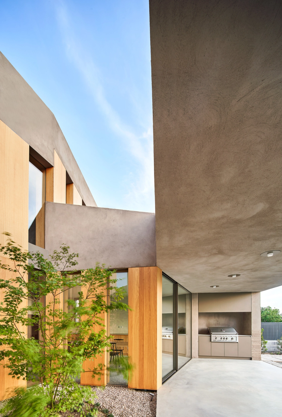 This single-family home combines natural materials and continuous finishes to create an elegant and contemporary architecture. The interior courtyard with vegetation brings light and freshness into the spaces, while the large glazed surfaces reinforce the connection between interior and exterior.