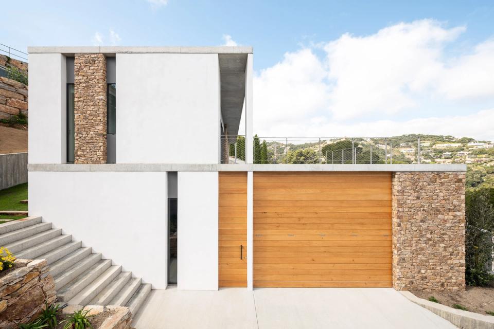 This detached single-family home stands out for its contemporary architecture and seamless relationship between interior and exterior spaces. Large sliding openings fully connect the main living areas with the terrace and outdoor spaces, maximizing natural light and open landscape views.