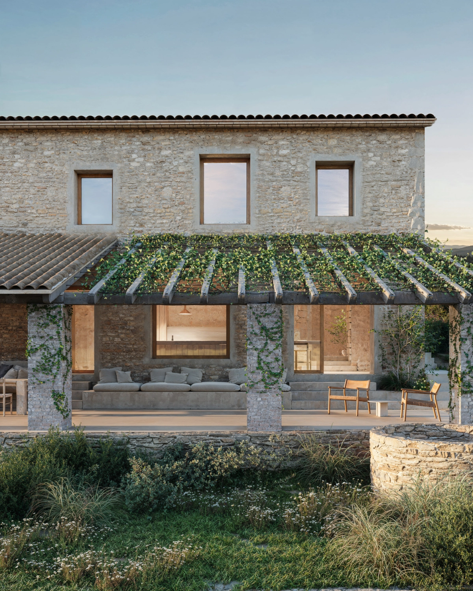 The renovation of a house in Les Gavarres restores the original character of the farmhouse with a covered porch space that acts as a transition between the interior and the landscape, bringing shade, calmness, and connection with the surroundings.