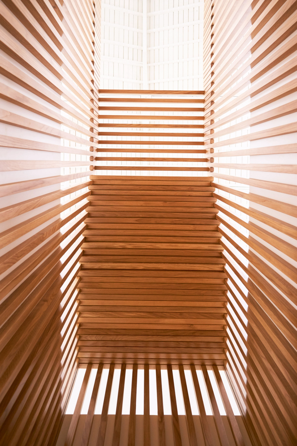 This full renovation redefines the interior through a distinctive architectural intervention based on natural wooden slats. This sculptural structure adds rhythm, depth and visual continuity while filtering zenithal light and creating a warm, bright and contemporary atmosphere throughout the home.