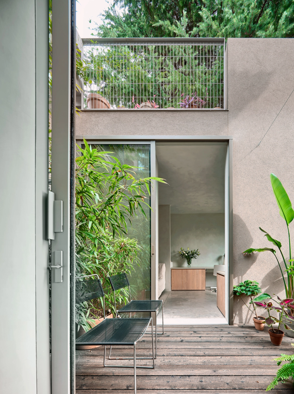 Housing renovation with a floor plan organized around two open courtyards that improve ventilation and natural light. The renovation redefines the interior layout to create more open, functional spaces connected to the outdoors.