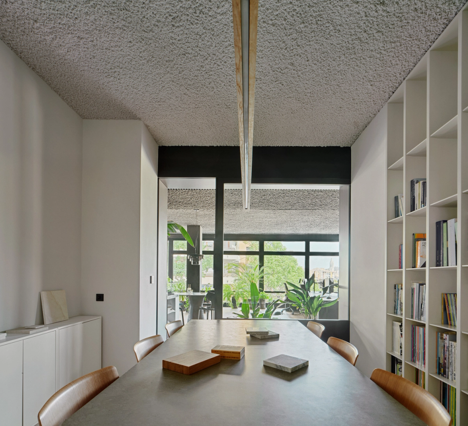 Reform of studio with an open and bright meeting room visually connected to the work areas. This studio renovation combines built-in shelving, neutral materials and large openings to create a professional, elegant and functional space.