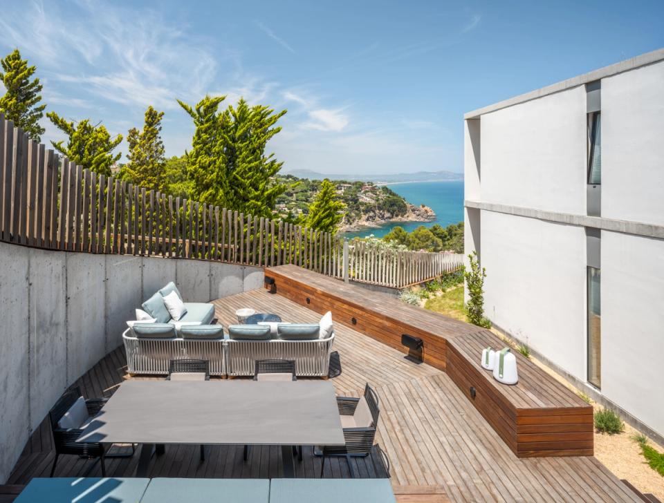 Detached single-family home with outdoor areas designed to enjoy the views and connection with the landscape. The wooden terrace and minimalist lines create a contemporary, functional space integrated into the natural environment.