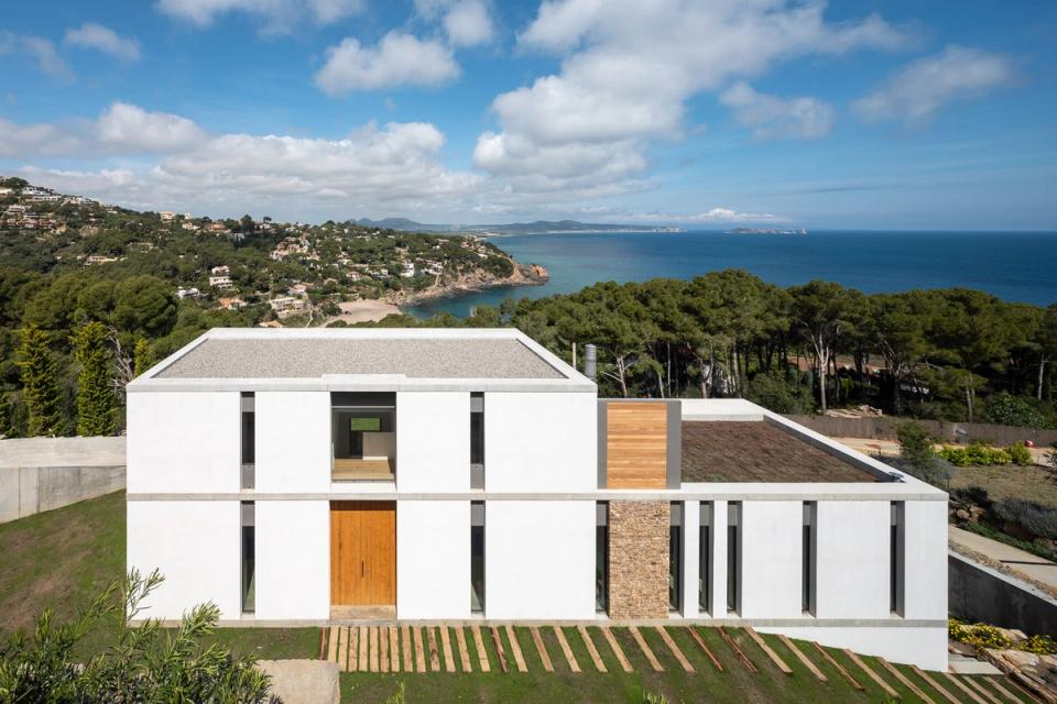 Detached single-family home with an exterior design integrated into the Mediterranean landscape. Concrete pathways, native vegetation, and minimalist architectural lines create an elegant and harmonious circulation around the residence.