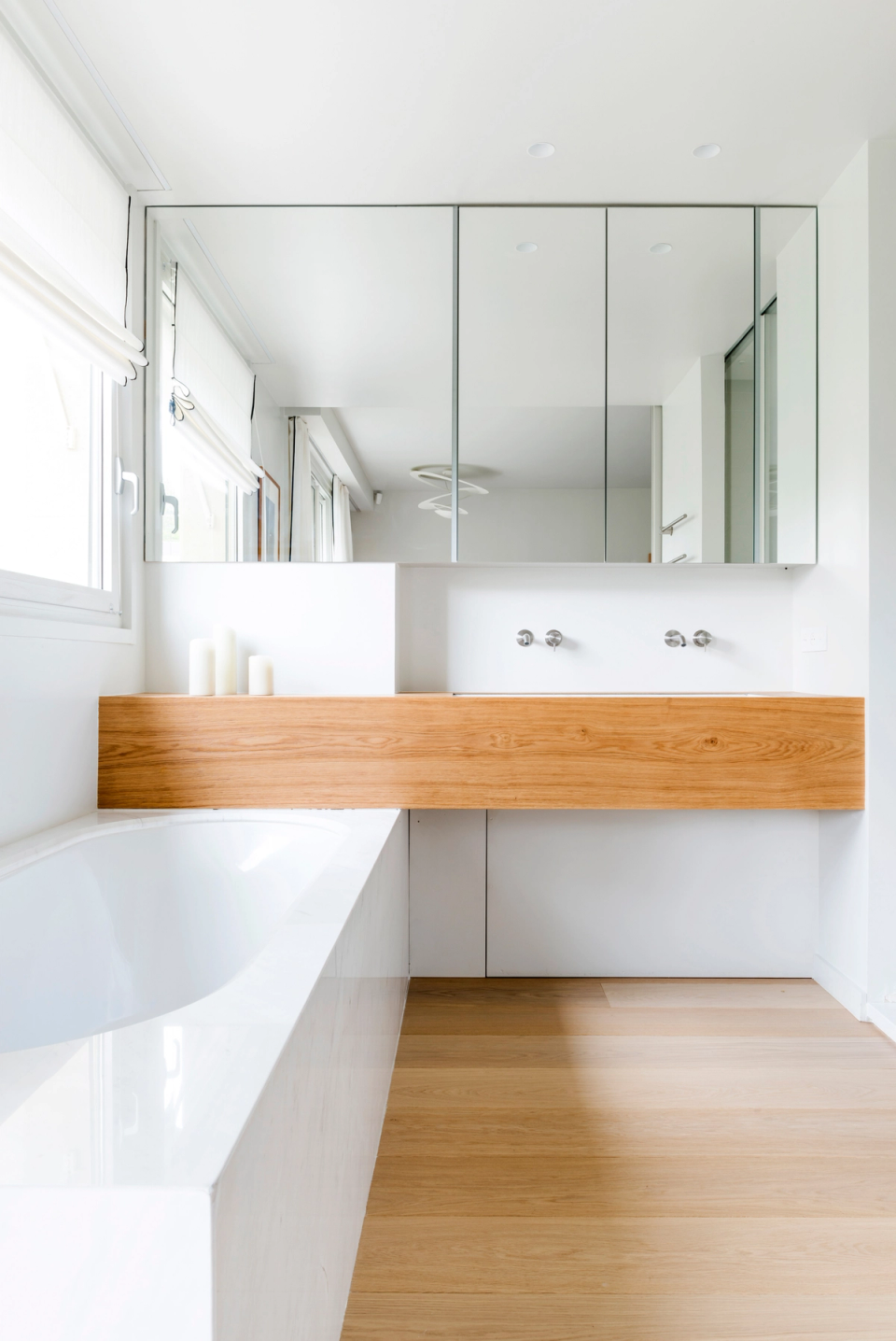 Interior renovation of a minimalist kitchen with a large central island conceived as the main feature of the space. The project combines stone-toned surfaces with natural wood cladding, creating a warm, elegant, and contemporary atmosphere. The open layout enhances the connection between the different areas of the home, while natural light and clean lines reinforce the feeling of order and spaciousness. A functional and timeless design intended to integrate kitchen, social interaction, and architecture into one harmonious space.