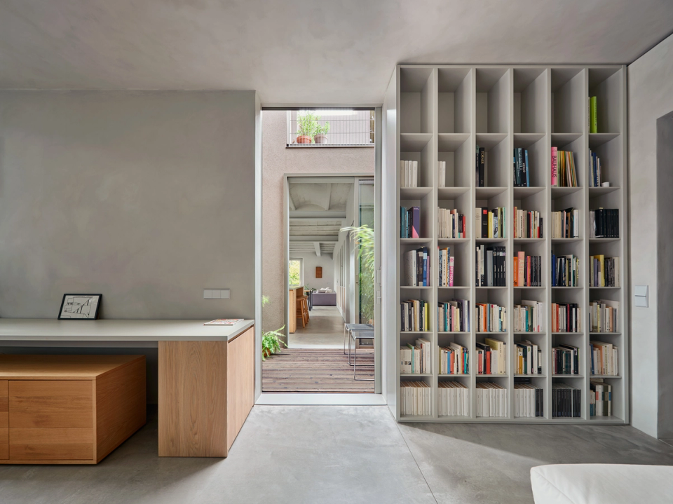 Housing renovation with an independent studio lit by a large window facing outdoors. The renovation creates calm, functional spaces connected to natural light to enhance comfort and focus.