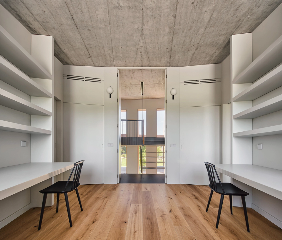 The interiors of this single-family home embrace simplicity, order, and functionality, with spacious rooms and noble materials that bring warmth and balance. The exposed concrete ceiling and natural wood create an elegant and contemporary contrast.
