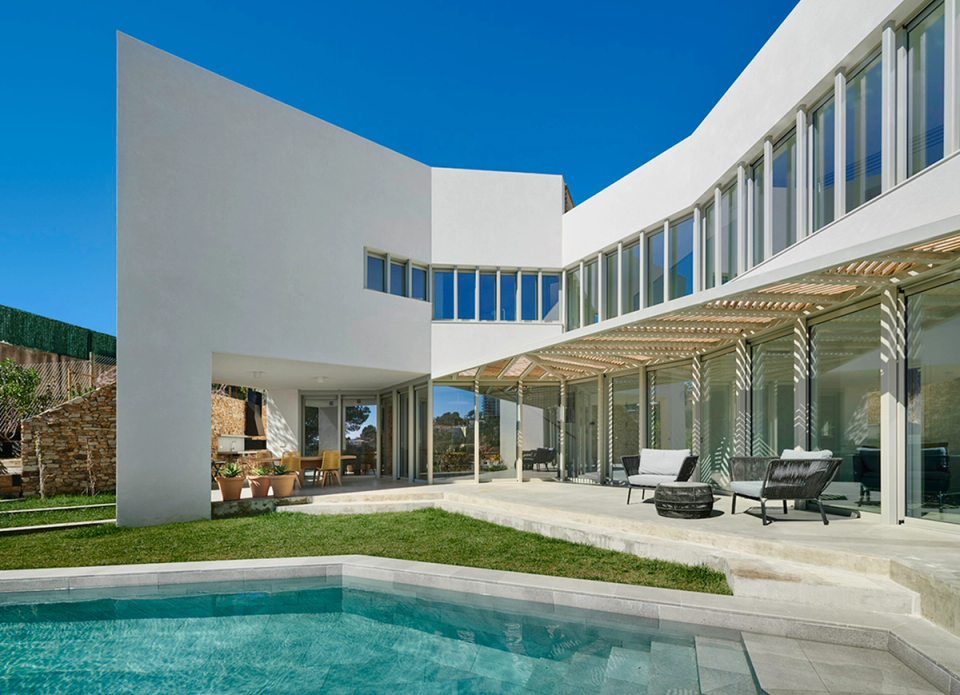 Detached single-family home with contemporary architecture defined by curved lines and open spaces that enhance natural light and the connection with the outdoors. Large glazed surfaces, lightweight porches, and the direct relationship with the swimming pool create an elegant, functional residential experience fully integrated into the Mediterranean environment.