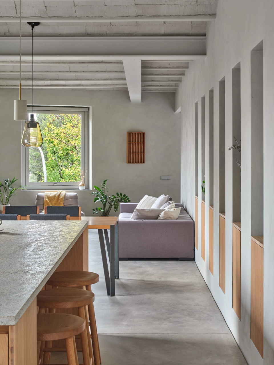 Housing renovation with open and continuous spaces that connect kitchen, dining and living areas into a single bright environment. The renovation combines natural materials, built-in furniture and large openings to enhance spaciousness and interior comfort.