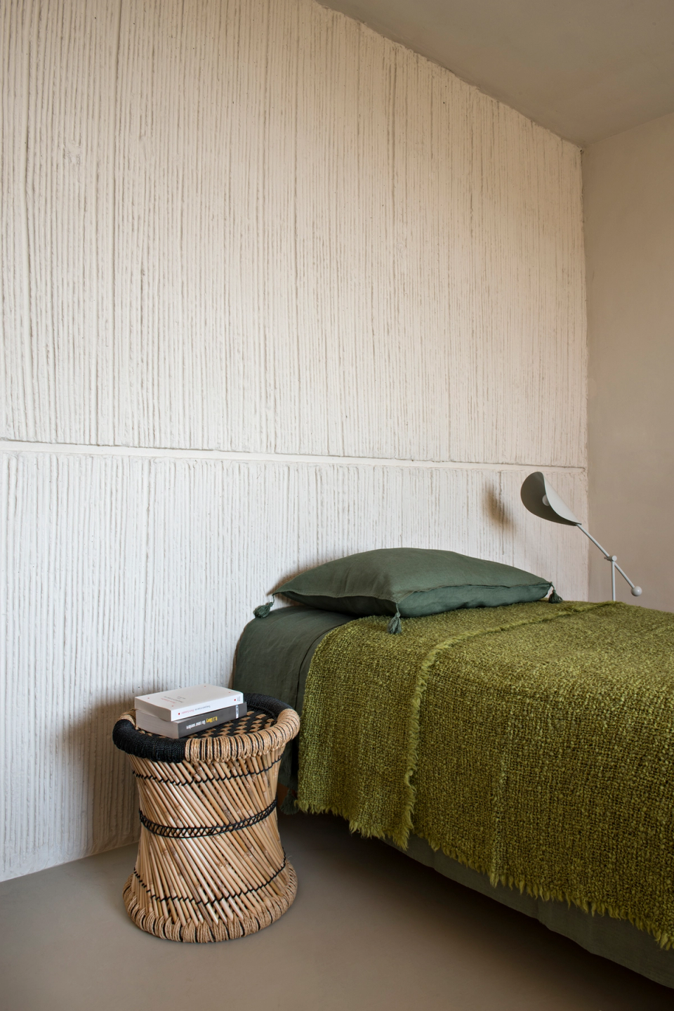 Interior detail of a detached house bedroom with a minimalist aesthetic and natural materials that bring warmth and authenticity to the space. The textured wall finish, earthy textiles and handcrafted furniture reinforce a serene and welcoming atmosphere aligned with the home’s contemporary Mediterranean architecture.