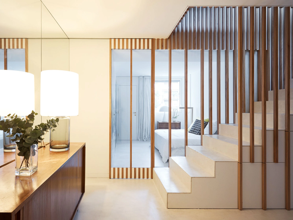 This full renovation combines warm materials and minimalist lines to create elegant, functional and visually connected spaces. The staircase, surrounded by a structure of natural wooden slats, acts as a dividing element without losing transparency or natural light, providing continuity, privacy and a strong architectural identity to the interior.