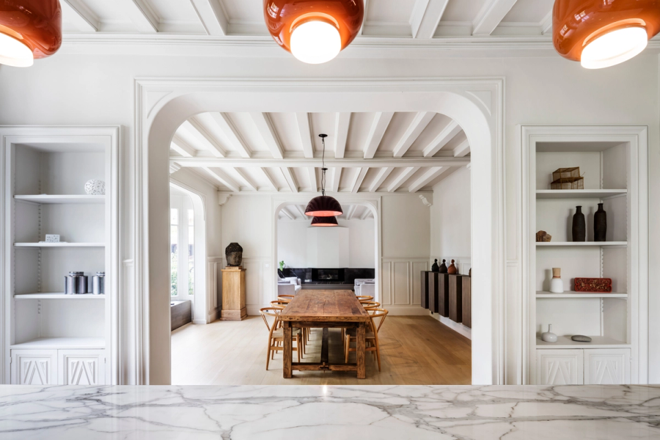 Interior renovation of a residence with an elegant and luminous proposal that combines original elements with contemporary finishes. The space stands out for its exposed beam ceilings, architectural arches, and the integration of premium materials such as wood and marble, creating an open and functional layout that enhances spaciousness and natural light.