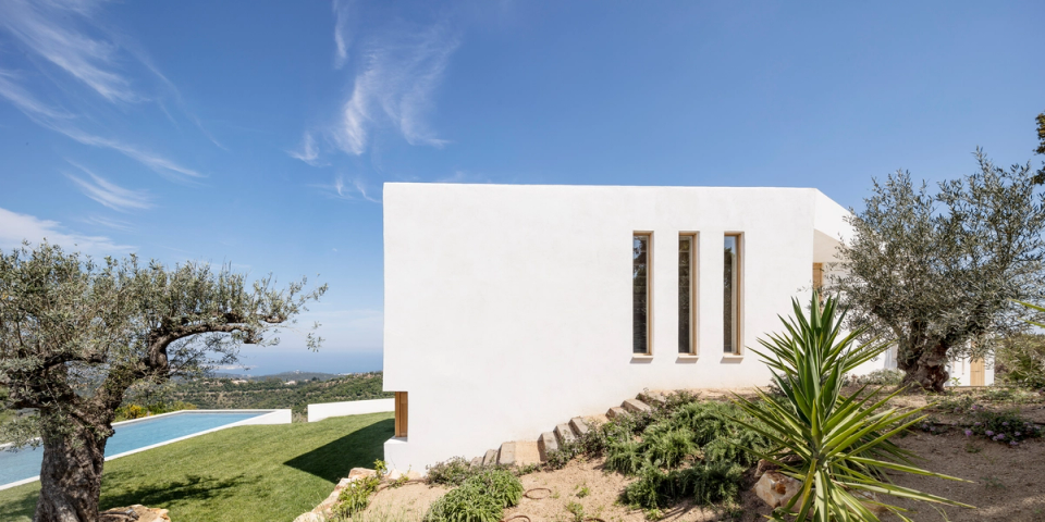 Contemporary detached house with pure lines and large openings oriented towards the landscape, conceived to maximize natural light and the relationship with the outdoors. The combination of white volumes, wooden carpentry and an integrated swimming pool creates an elegant Mediterranean home perfectly connected to its natural environment.