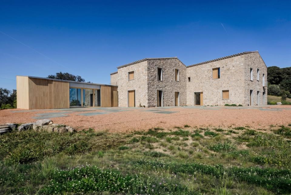 Reforma integral de masía con una propuesta arquitectónica que fusiona la arquitectura tradicional con una ampliación contemporánea de líneas minimalistas y materiales naturales. El proyecto recupera la estructura original de piedra, manteniendo la autenticidad y el carácter rústico del edificio, al mismo tiempo que incorpora nuevos espacios con fachadas de madera y grandes cerramientos de vidrio que aportan luminosidad, eficiencia y confort. La intervención crea un conjunto armonioso integrado en el paisaje, donde la reforma integral respeta la identidad de la construcción existente y la transforma en una vivienda moderna, funcional y adaptada a las necesidades actuales.