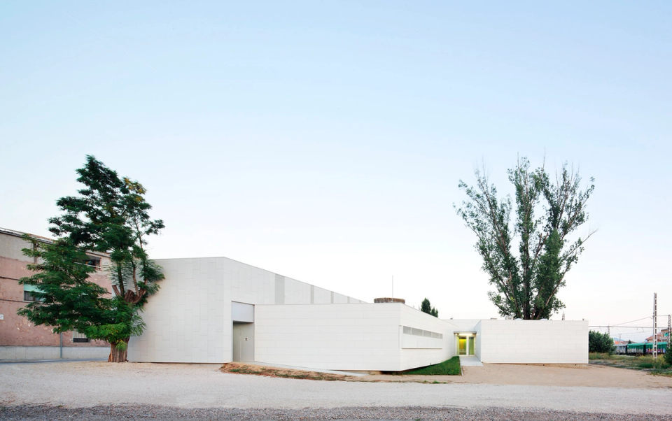  External image of CAP Sant Vicenç, a project of healthy health architecture that combines functionality, natural light and urban integration. The building, with horizontal geometry and contemporary expression, generates accessible and serene spaces, enhancing the well-being of users and the friendly relationship with the environment. The white composition of the volumes and the recovery of the existing deposit reinforce the identity and sustainable character of the architectural ensemble.