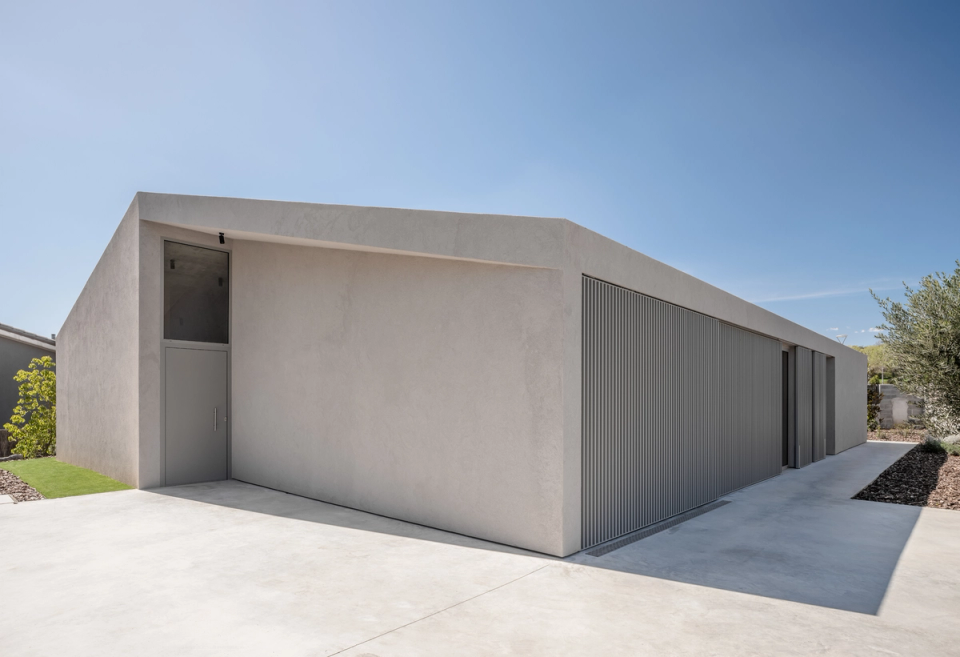 This single-family home embraces an austere and contemporary architecture, with a compact volumetry and straight lines that convey balance and functionality. The continuous façade and the use of vertical metal slats provide rhythm and solar protection to a minimalist project that prioritizes privacy, natural light, and integration with the outdoor environment.