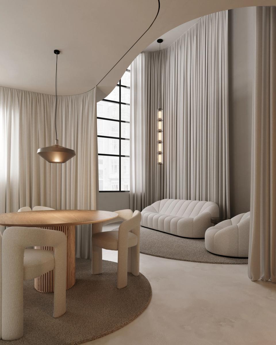 Alternative view of the same contemporary room, with prominence of the dining room furniture formed by a design table and high standard chairs with elegant lines and organic shapes. The space maintains a palette of beige tones, broken white and soft gray, creating a warm, sophisticated and very bright atmosphere. The grey carpet, delicate textures and curved furniture reinforce the visual harmony of the integral reform. Design lamps and the entry of natural light enhance the exclusive character of interior design. Ideal photography to represent architecture projects, apartment renovations and luxury integral reforms.