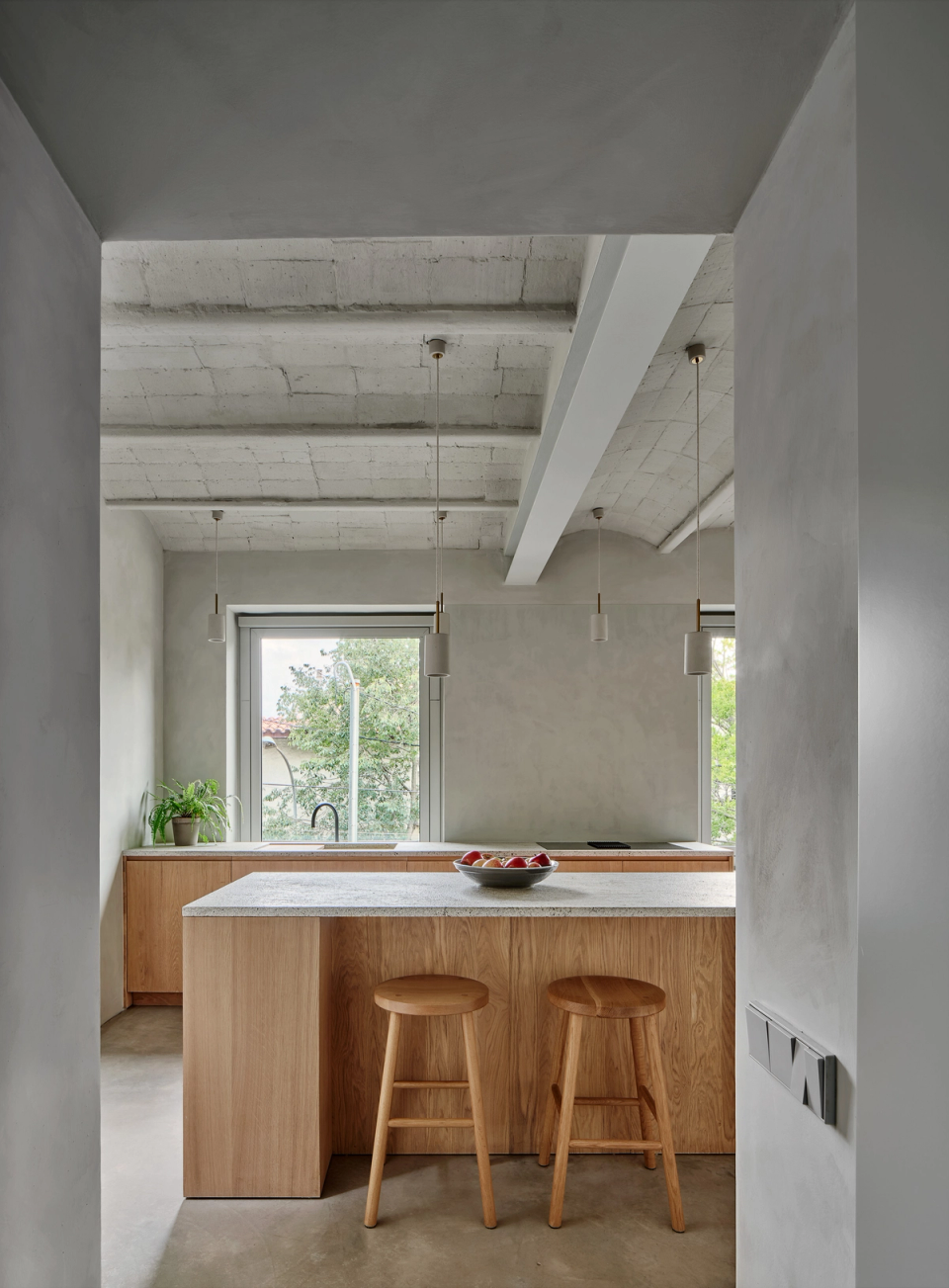 Housing renovation with an open kitchen combining functionality, natural light and warm materials. The renovation focuses on continuous spaces and a fluid layout that enhances spaciousness and interior comfort.