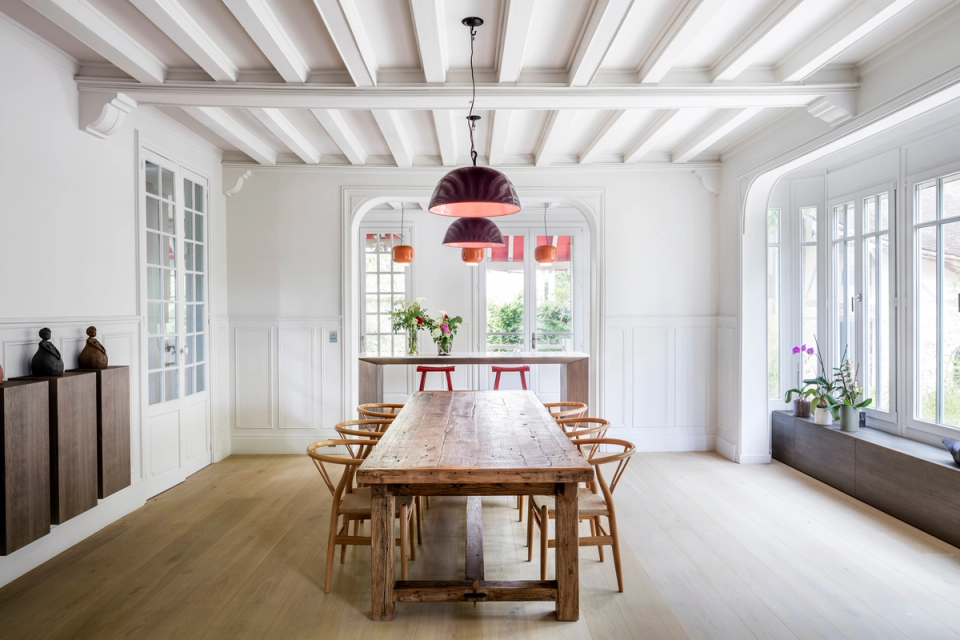 Interior renovation of a dining room that recovers the original architectural essence of the residence through a contemporary approach. Exposed beam ceilings, moldings, and large windows bring brightness and elegance, while the combination of natural wood, handcrafted furniture, and designer lighting creates a warm, balanced, and sophisticated atmosphere.
