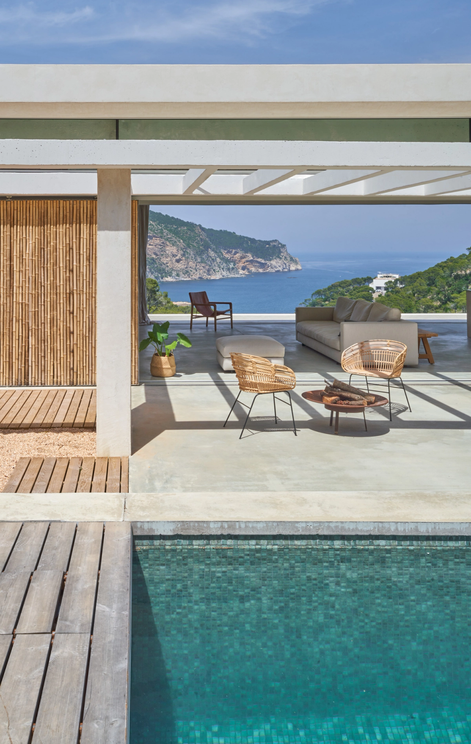 This single-family home has been conceived to maximize the connection with the landscape and sea views through open, bright, and deeply Mediterranean architecture. The covered outdoor spaces integrate naturally with the pool and living areas, creating a fluid continuity between interior and exterior. The combination of white structures, natural materials, and wooden enclosures provides warmth and balance to a contemporary and minimalist proposal. This single-family home stands out for its direct relationship with the surroundings, the quality of its open spaces, and an architecture designed to enjoy light, climate, and the coastal landscape.