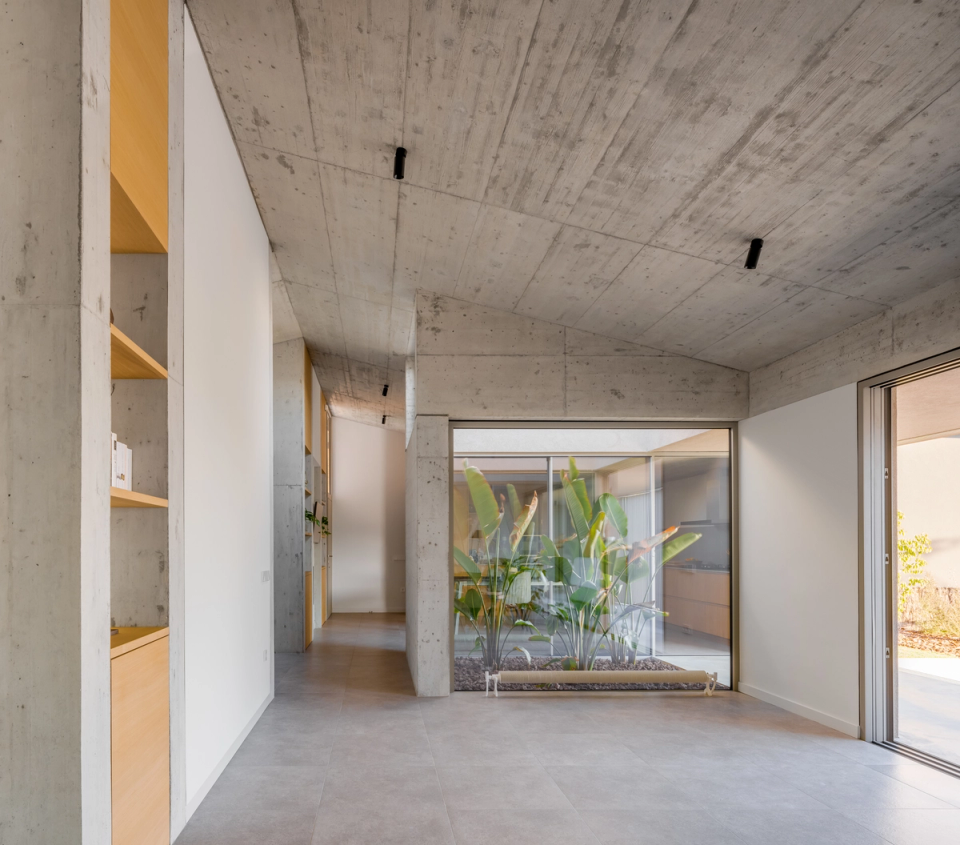 This single-family home stands out for the fluidity of its spaces and the integration of interior courtyards that allow constant natural light entry. The use of exposed concrete, large openings, and minimalist finishes defines a contemporary, functional architecture connected to nature, creating a sense of spaciousness and serenity throughout the home."