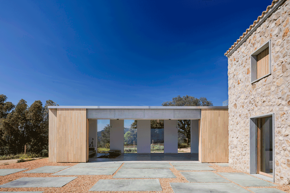 Complete renovation of a traditional farmhouse with a contemporary extension distinguished by the balanced combination of natural stone, wood, and exposed concrete. The architectural project redefines both exterior and interior spaces through a minimalist and functional intervention, preserving the rustic essence of the original building while incorporating new open and light-filled volumes. The connection between architecture and landscape is reinforced through open porches, large visual openings, and natural materials that provide warmth and integration with the surroundings. A comprehensive renovation that transforms the home into a contemporary, elegant space perfectly adapted to modern needs.