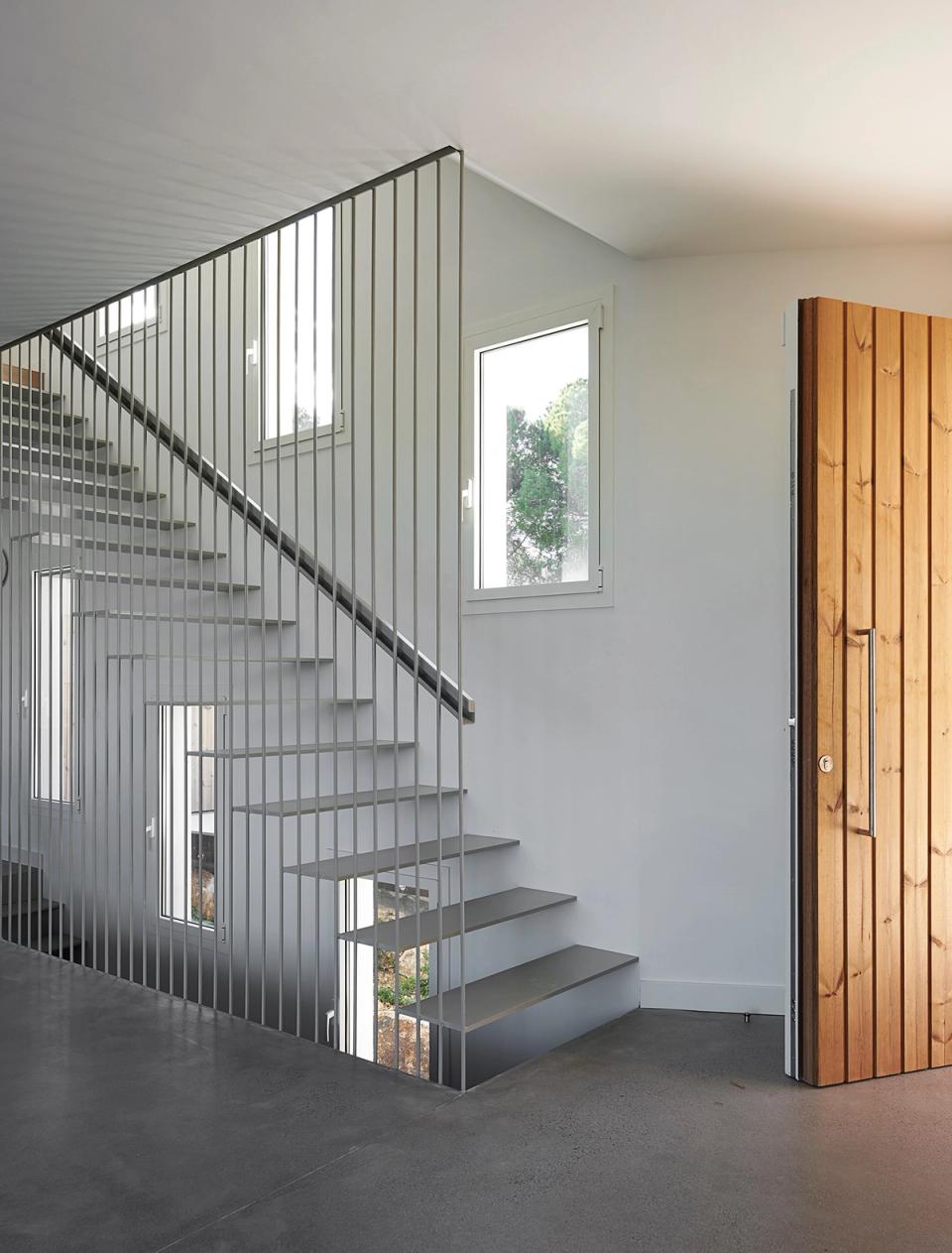 Detached single-family home with an open-plan minimalist kitchen combining functionality, natural light, and premium materials. Large windows connect the interior with the exterior, while neutral finishes and wood elements add warmth and elegant contemporary style.