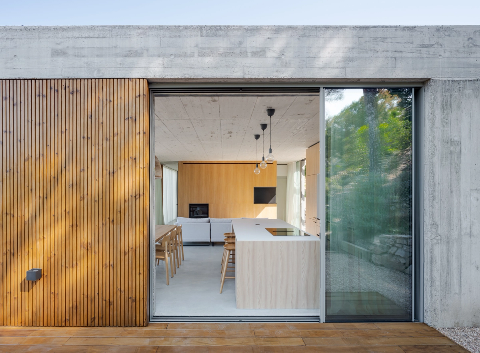 This single-family home in Begur reflects a contemporary architecture based on formal simplicity, natural materials, and a constant connection with the outdoors. The large glazed openings, combined with exposed concrete and wood cladding, create bright, warm spaces open to the Mediterranean landscape, promoting a flexible, functional lifestyle integrated with the surroundings.