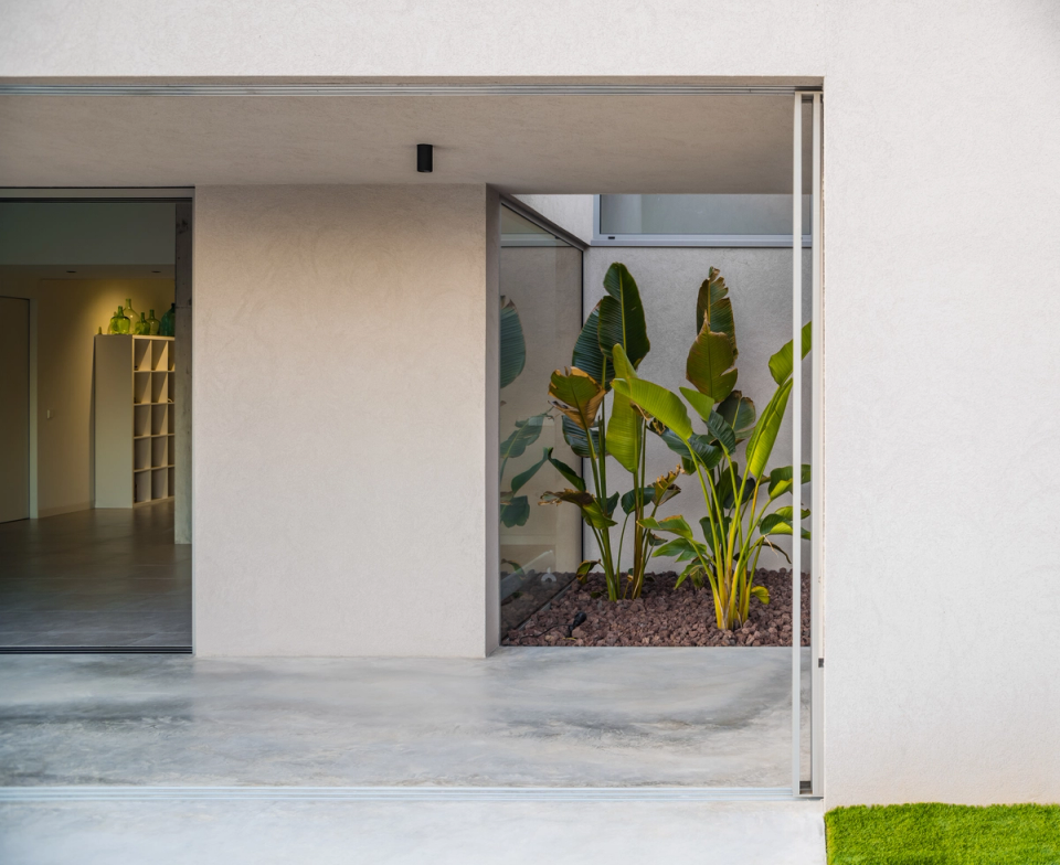 This single-family home uses interior courtyards and large openings to create a constant relationship between interior and exterior. Integrated vegetation, neutral materials, and minimalist architectural lines provide light, spaciousness, and a contemporary atmosphere focused on comfort and connection with the surroundings.