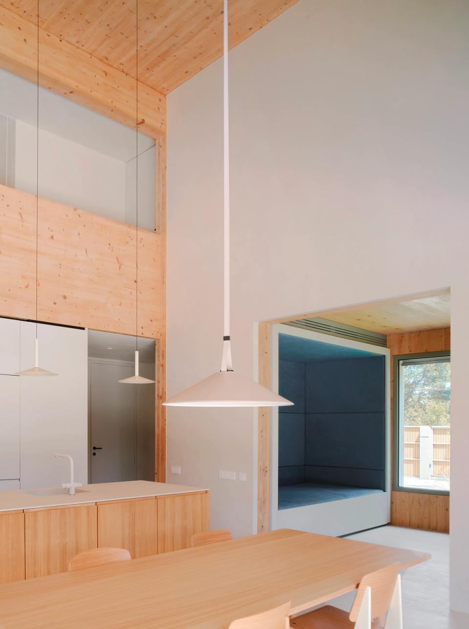 House in Girona with an independent workspace visually connected to the garden and natural light. This house in Girona combines minimalist architecture, warm materials, and large openings to create a calm, functional, and comfortable atmosphere