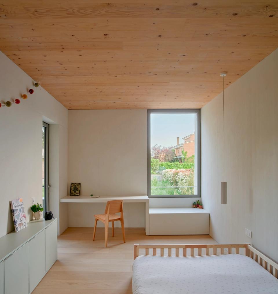 House in Girona with a minimalist childre'n room integrated into a spacious and bright environment clad in natural wood. This house in Girona combines warm materials, functional furniture, and contemporary architecture designed to encourage social interaction and natural light