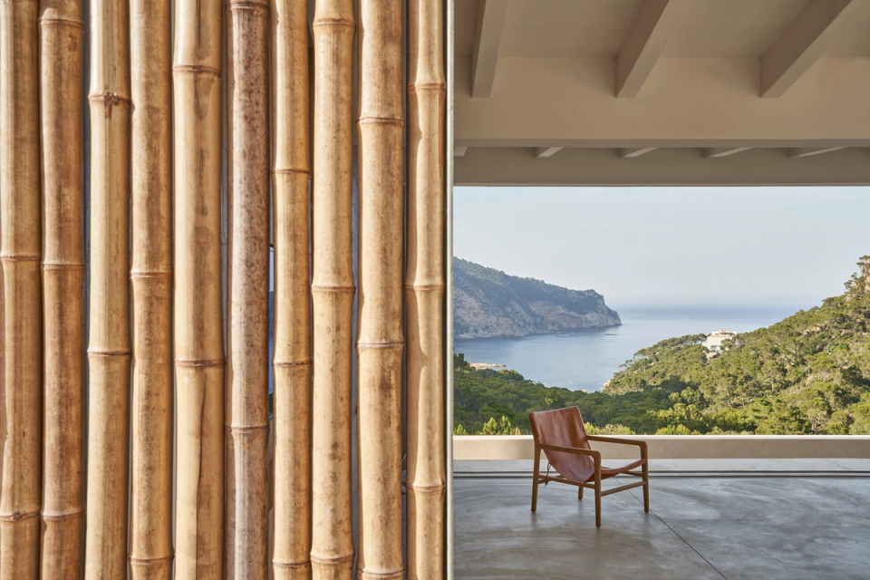 This single-family home establishes a direct connection with the Mediterranean landscape through large panoramic openings and natural elements integrated into the architecture. Cane filters provide privacy and solar control without losing the visual relationship with the exterior, creating a play of light and textures that reinforces the warm and organic character of the space. The minimalist composition, noble materials, and open sea views create a serene and contemplative atmosphere. This single-family home stands out for contemporary architecture that combines interior and exterior fluidly, enhancing natural light and integration with the surroundings.