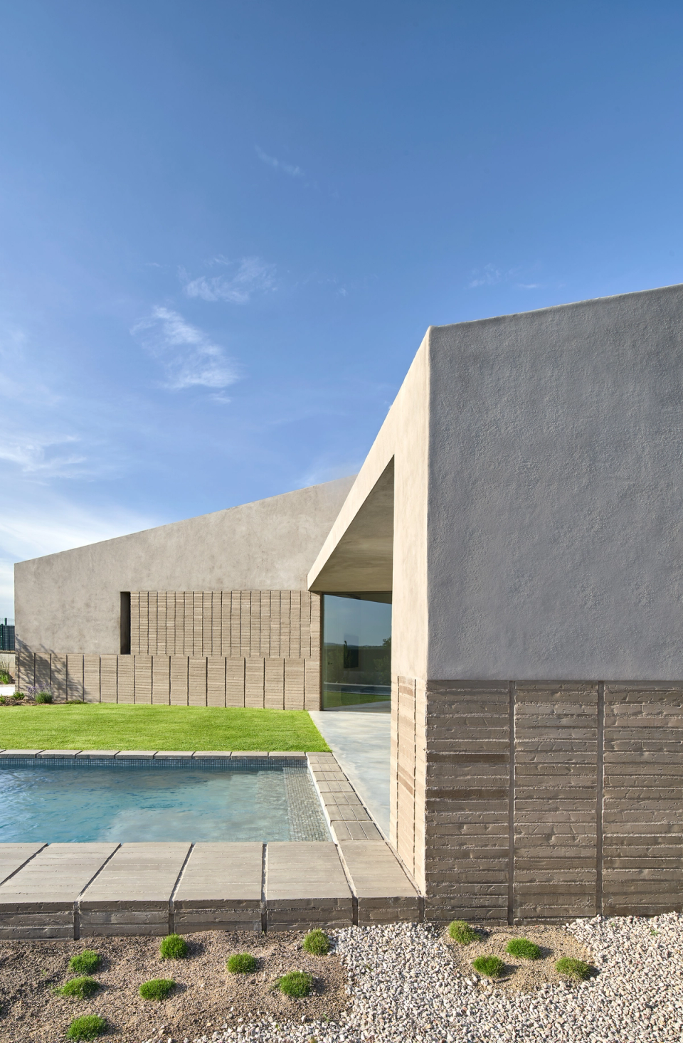 The exterior architecture of this single-family home embraces pure lines, solid volumes, and natural materials that engage in dialogue with the landscape. The combination of mineral cladding, ceramic textures, and spaces open to the garden creates a contemporary, sober, and balanced image.