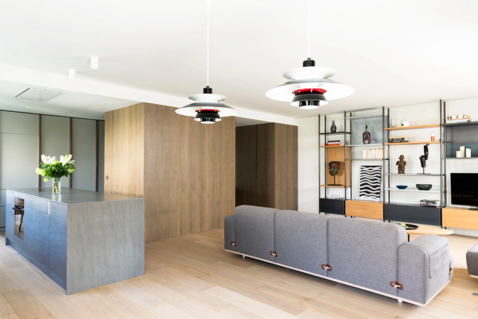 The interior renovation embraces an open and contemporary space where the kitchen, dining area, and living room connect fluidly. Natural wood finishes, neutral tones, and integrated furniture provide warmth and visual coherence, while natural light enhances the spaciousness and comfort of the home.
