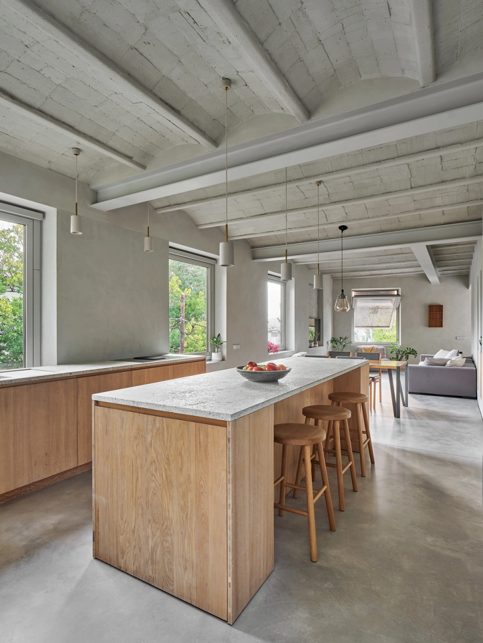 Housing renovation with an open kitchen and open-plan spaces that enhance visual continuity and natural light. The renovation combines original ceilings, natural materials and an open layout to create a warm and contemporary atmosphere.