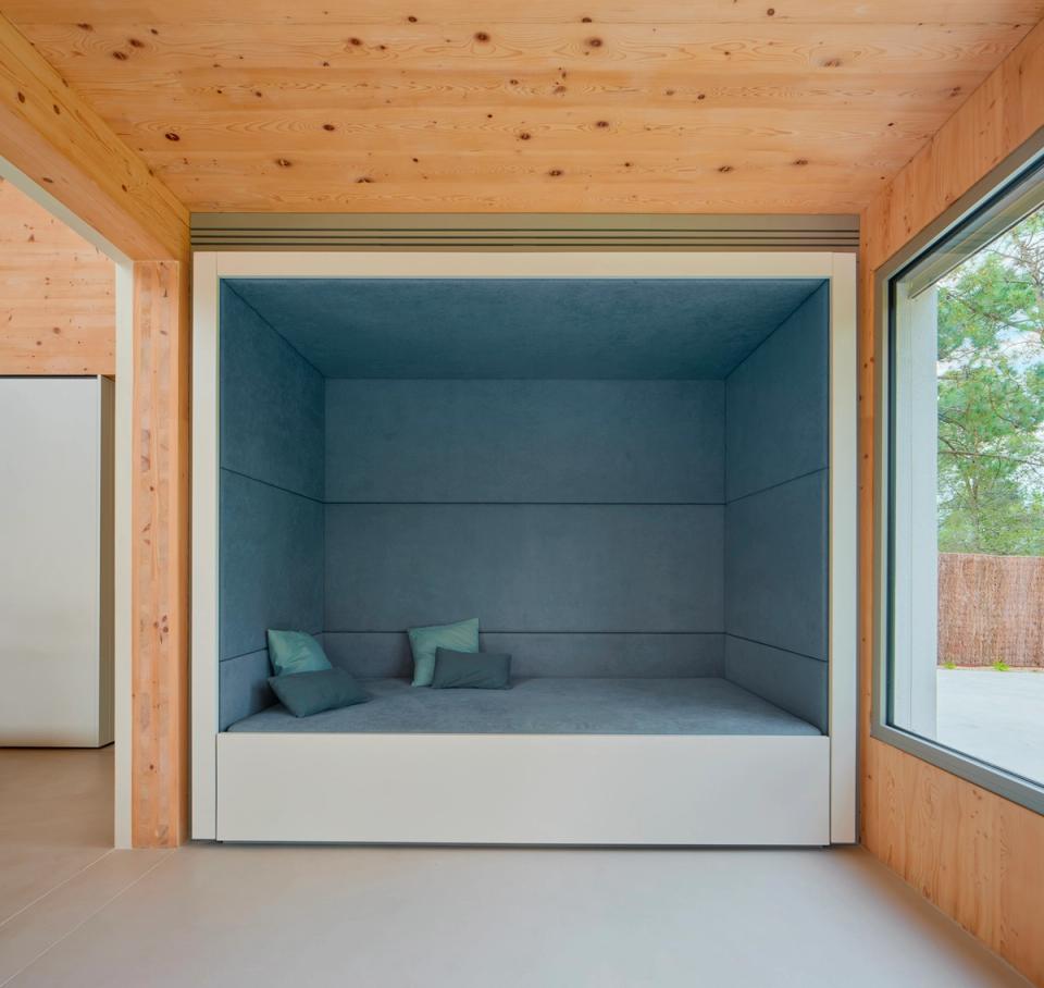House in Girona with a double-height living area integrating the kitchen, dining room, and relaxation spaces into a bright and spacious environment. This house in Girona uses natural wood, minimalist lines, and large openings to create warm, contemporary, and functional architecture
